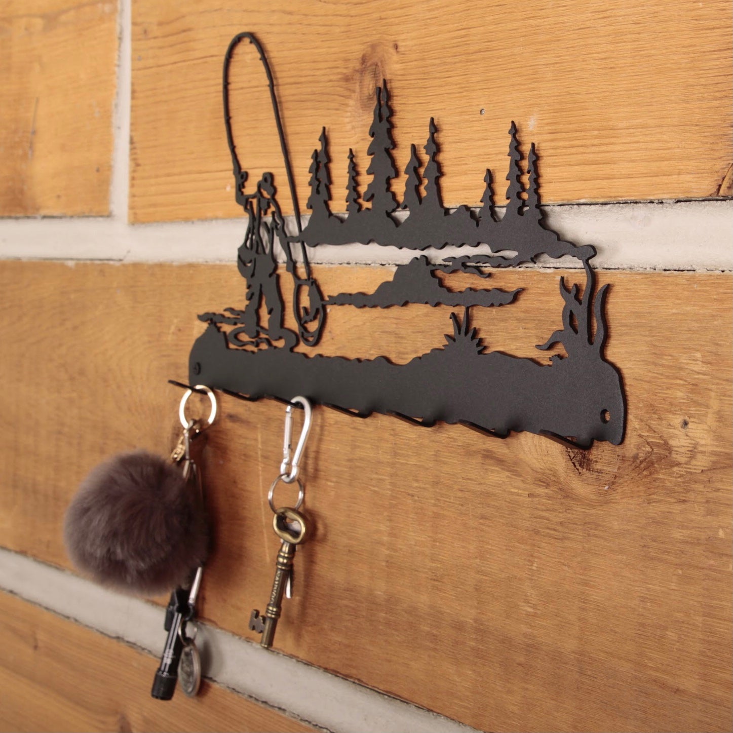 Decorative metal key holder with nature design on a wooden wall